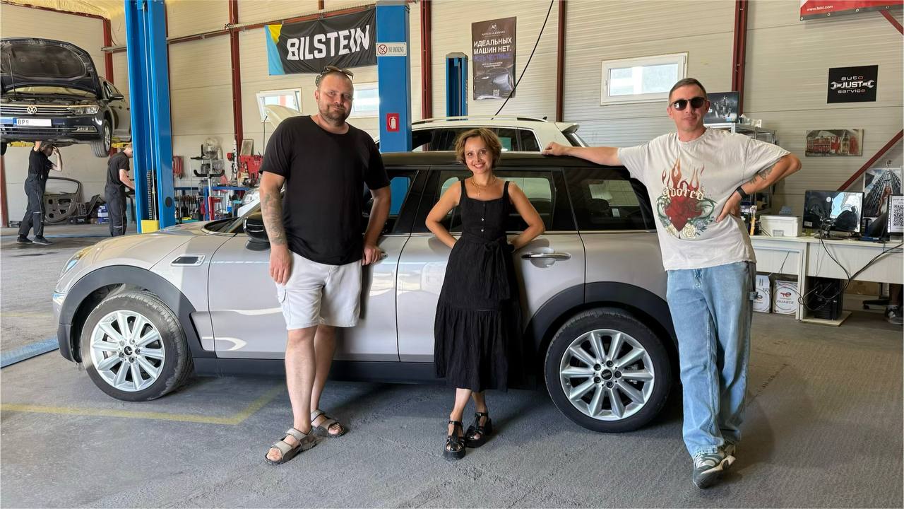 Владельцы и команда рядом с MINI Clubman при передаче автомобиля